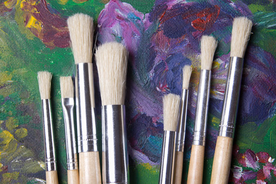 close up of wooden paint brushes on oil paints