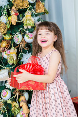 Happy little girl with christmas present smiling