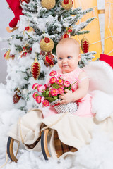 Little girl with gifts under the Christmas tree