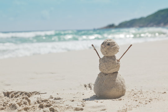 snowman made of sand on a background of the tropical warm sea