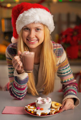 Portrait of smiling  girl in santa hat having christmas snacks