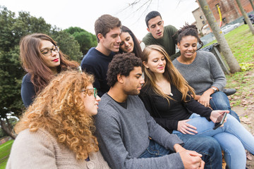 Fototapeta na wymiar Multiethnic Group of Friends Looking at Mobile Phone