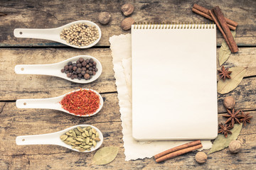 Recipe notepad with diversity of spices and herb.