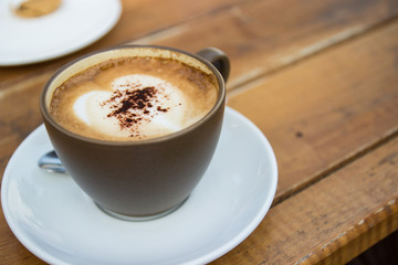 a cup of expresso coffee with heart-shape foam on top