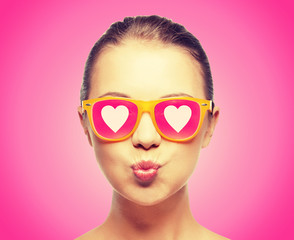 girl in pink sunglasses blowing kiss