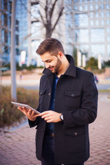 A smart young businessman with a beard using a tablet computer