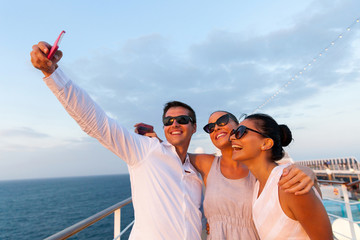 group of friends taking self portrait using smart phone