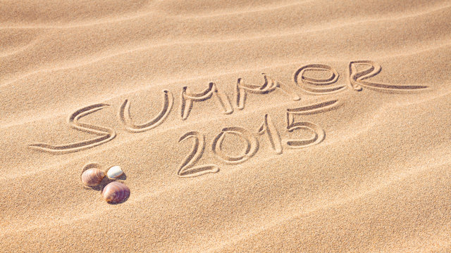 Summer 2015 handwriting with shells on a wavy pattern of sand