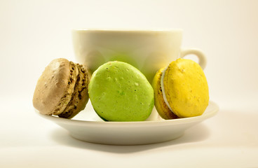 Multicolor macaroon cookies and white coffee cup