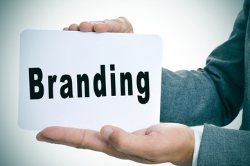 man in suit with a signboard with the word branding