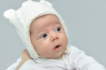 Cute newborn baby girl with white knitted woolen winter cap