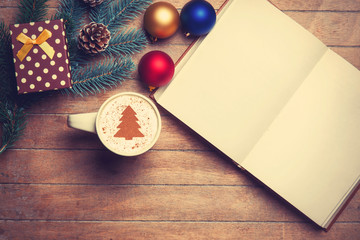 Cappuccino and opened book on wooden table near toys.