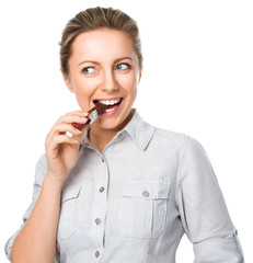 portrait of a young woman biting chocolate isolated on white