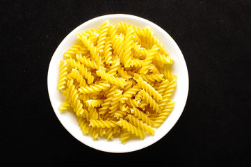 Raw italian fusilli pasta in the white bow top view