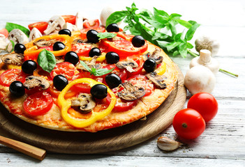 Delicious pizza served on wooden table