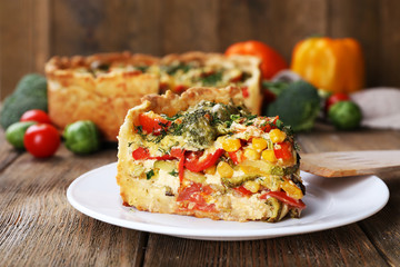 Piece of Vegetable pie with broccoli, peas, tomatoes and cheese