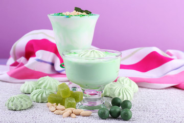 Mint milk dessert in glass bowls on color wooden background