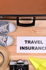 Suitcase and tourist stuff with inscription travel insurance