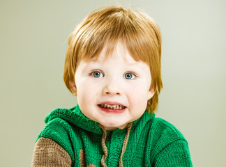 little boy in green sweater scared reaction portrait