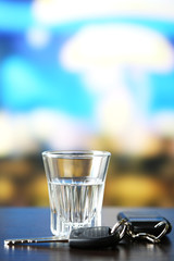 Glass of alcoholic drink and car key,