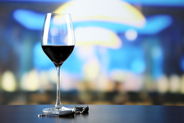 Glass of alcoholic drink and car key,