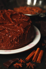Chocolate cake with chocolate cream on wooden table close-up