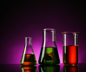 Test tubes with liquid on dark colorful background