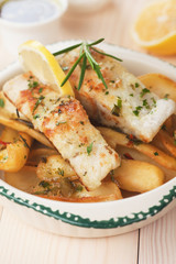 Cod fish steak with fried potato and lemon