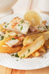 Cod fish steak with fried potato and lemon