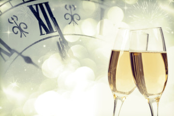 Glasses with champagne and clock close to midnight