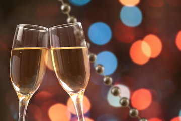 Champagne glasses against holiday lights
