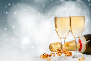 Glasses with champagne and bottle over holiday background