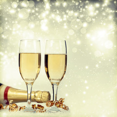 Glasses with champagne and bottle over holiday background
