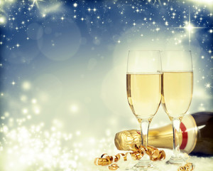 Glasses with champagne and bottle over holiday background