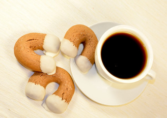 Ginger biscuits horseshoe shape with white cup of coffee