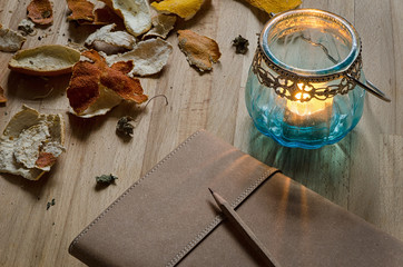 notebook and candle lantern with dried fruit peel