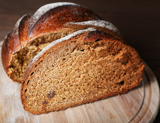 The cut black bread on a wooden table