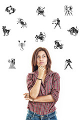  woman surrounded with zodiac signs thoughtfully looking up with