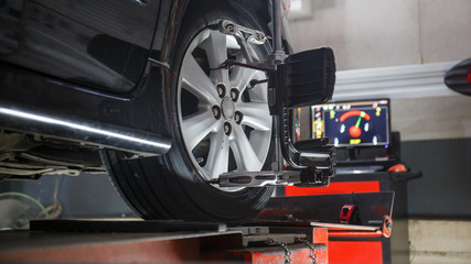 Car on stand with sensors on wheels for wheels alignment camber - obrazy, fototapety, plakaty