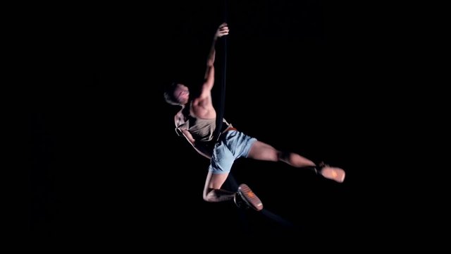 Young man air gymnast on black background