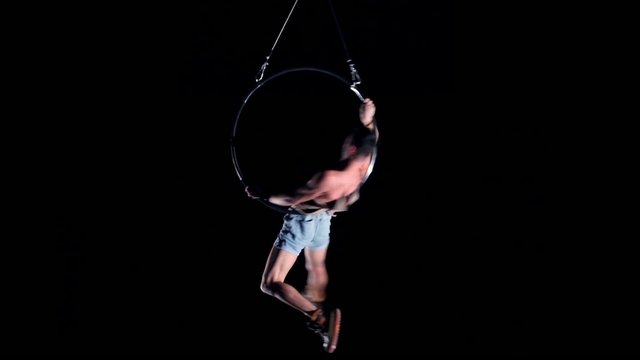 Young man air gymnast on black background