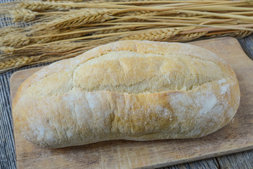 Bread and Wheat on Rustic Wood Background