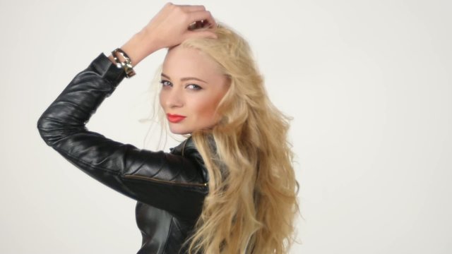 Fashionable beautiful blonde woman posing in studio in black