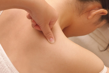 closeup asian woman having deep massage on her shoulder in spa