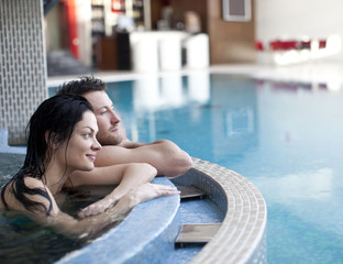 Couple relaxing in jacuzzi of spa center  - obrazy, fototapety, plakaty