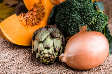 Close-up artichoke, sliced pumpkin, onion and broccoli.