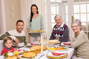 Obraz na płótnie Canvas Woman holding christmas dinner with family