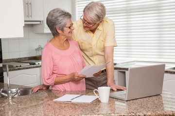 Senior couple paying their bills with laptop
