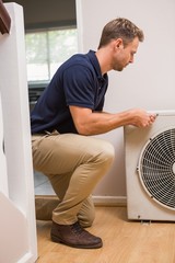 Focused handyman fixing air conditioning