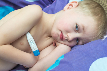 Obraz na płótnie Canvas Boy Grip patient lying in bed with a thermometer
